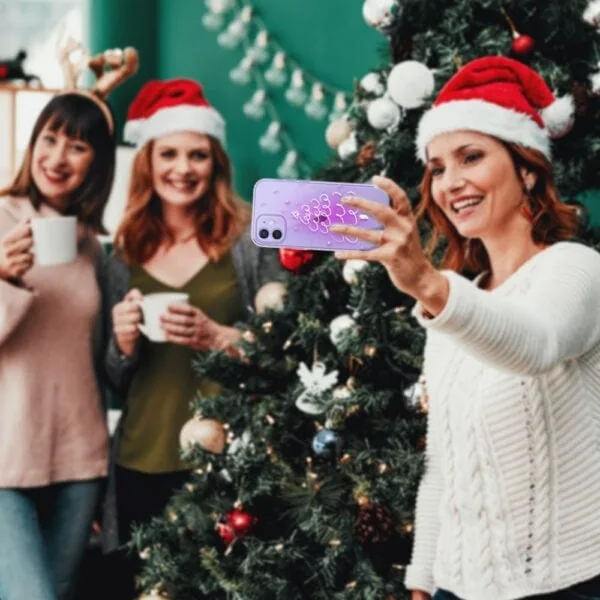 Kobiety robią selfie przy choince świątecznej.