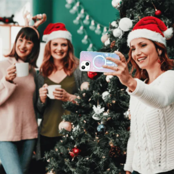 Kobiety robią selfie przy choince, świąteczne czapki.