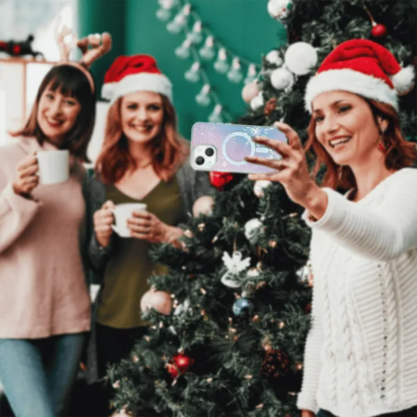 Kobiety robią selfie przy choince, świąteczne czapki.