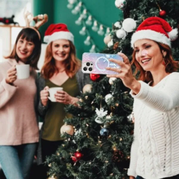 Etui do iPhone 16 Pro Max MagSafe Christmas, płatki śniegu, zmieniające kolor (1) Przyjaciele robią selfie przy choince świątecznej.
