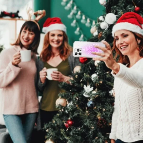 Etui do iPhone 16 Pro Max, malowana choinka na różowym świetle, przeźroczyste (2) Przyjaciele robią selfie przy choince świątecznej.