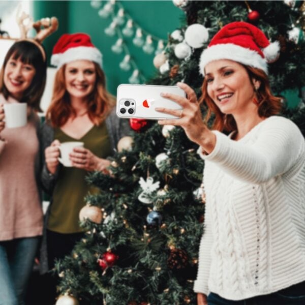 Etui do iPhone 16 Pro, czapka Mikołaja (6) Przyjaciele robią selfie przy choince.