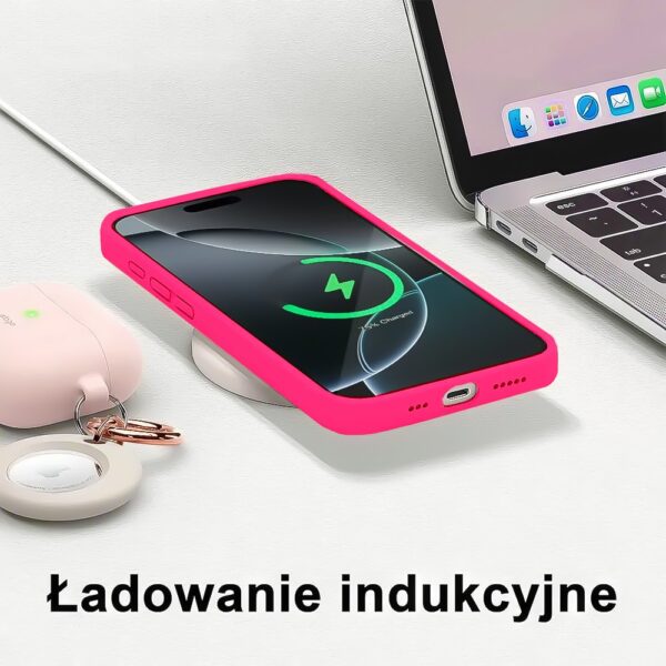 Smartfon na ładowarce indukcyjnej, różowa obudowa.