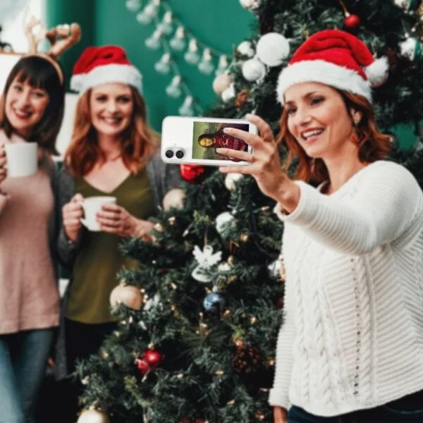 Kobiety robią selfie przy choince.